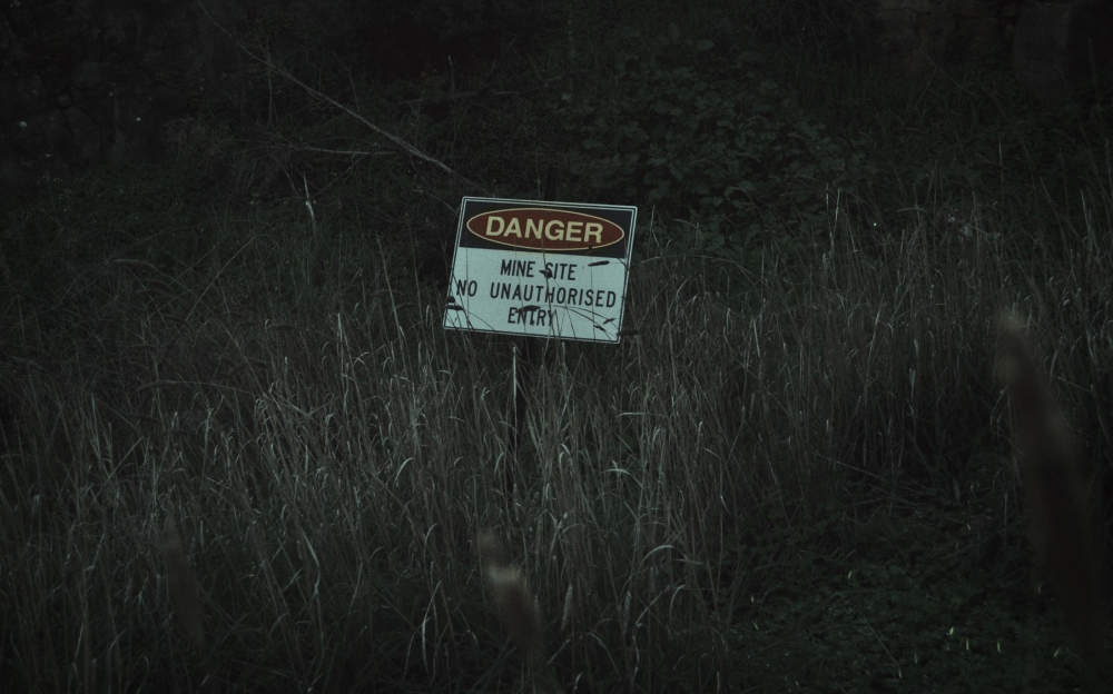 A warning sign with the words Danger mine site