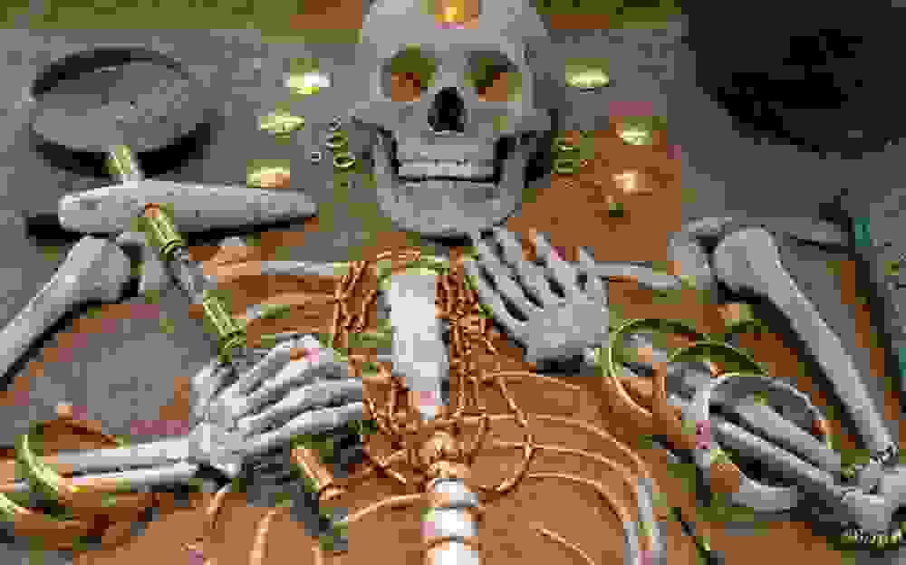 A skeleton surrounded by gold coins